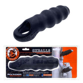 The Oxballs Invader "Black Ice" Cocksheath Penis Extender, made from ribbed PLUS+SILICONE, is shown above its packaging. This black penis extender includes product branding and an illustration highlighting its application.